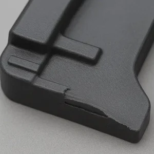Short shot defect on an injection-molded plastic part, showing incomplete fill and missing end geometry