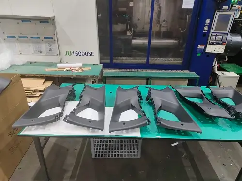 Plastic injection molded parts arranged for inspection inside JeekMould production workshop