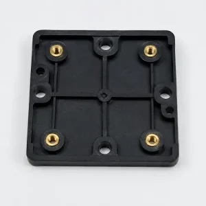 Injection molded plastic base with brass heat set inserts for secure screw fastening