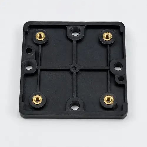 Injection molded plastic base with brass heat set inserts for secure screw fastening