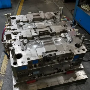 Large injection mold during manufacturing with precision machined cavities in a factory workshop